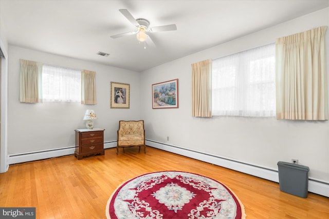 1122 N 14th St, Allentown, PA 18102 - living area featuring wood finished floors, ceiling fan, and a baseboard heating unit