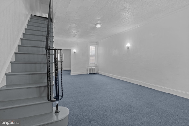 stairway with radiator, carpet floors, and a textured ceiling
