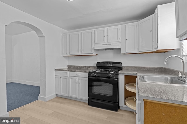 kitchen with black gas range oven, under cabinet range hood, light wood-type flooring, white cabinets, and arched walkways