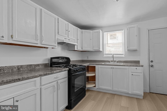 kitchen featuring black gas range, under cabinet range hood, white cabinetry, and light wood-type flooring