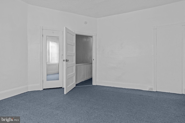 empty room featuring dark carpet