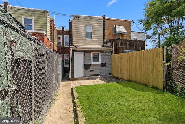 back of house with a fenced backyard