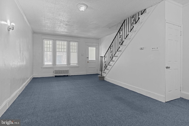 entryway featuring radiator, dark colored carpet, stairway, and a textured ceiling