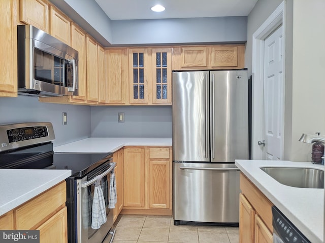 74 Avon Ln Unit 7D, New Hope, PA 18938 - kitchen featuring appliances with stainless steel finishes, light brown cabinetry, light countertops, light tile patterned floors, and glass insert cabinets