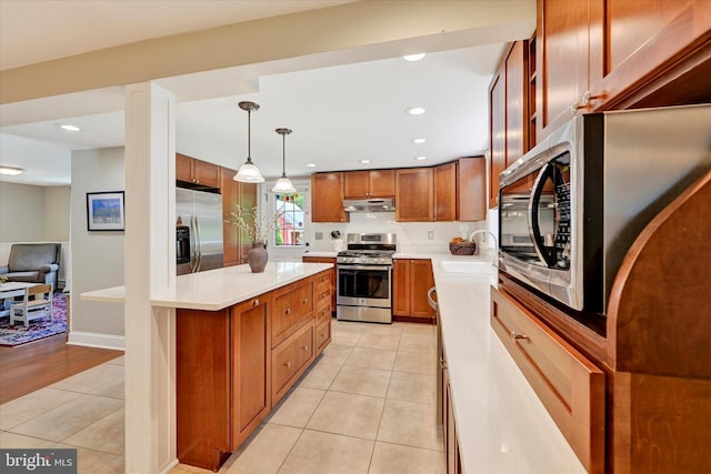 17435 Big Falls Rd, Monkton, MD 21111 - kitchen with stainless steel appliances, under cabinet range hood, light tile patterned floors, light countertops, and brown cabinetry