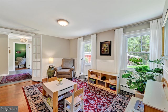 17435 Big Falls Rd, Monkton, MD 21111 - living area featuring a wainscoted wall, baseboard heating, wood finished floors, and a chandelier