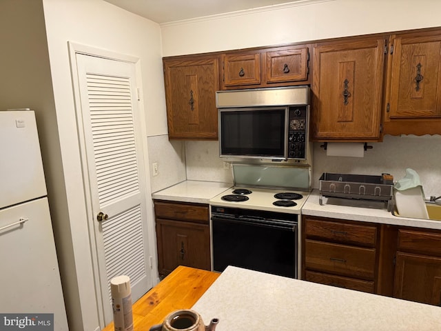 170 E Holly Ln, Tuckerton, NJ 08087 - kitchen with stainless steel microwave, range with electric cooktop, light countertops, and brown cabinets