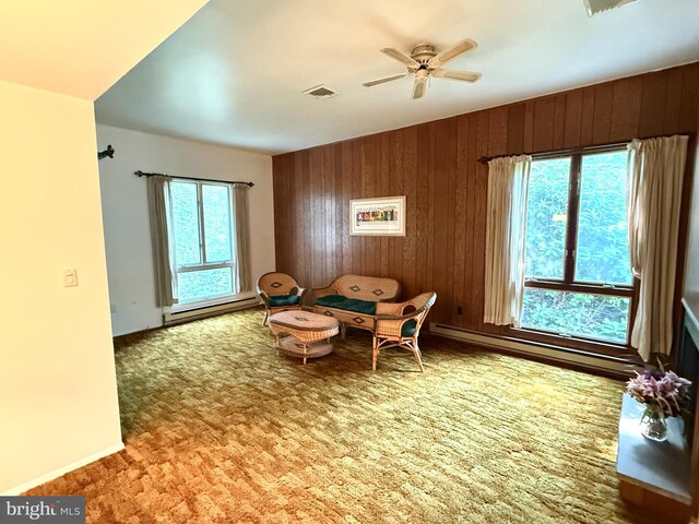 170 E Holly Ln, Tuckerton, NJ 08087 - living area with wooden walls, ceiling fan, carpet flooring, and a baseboard heating unit