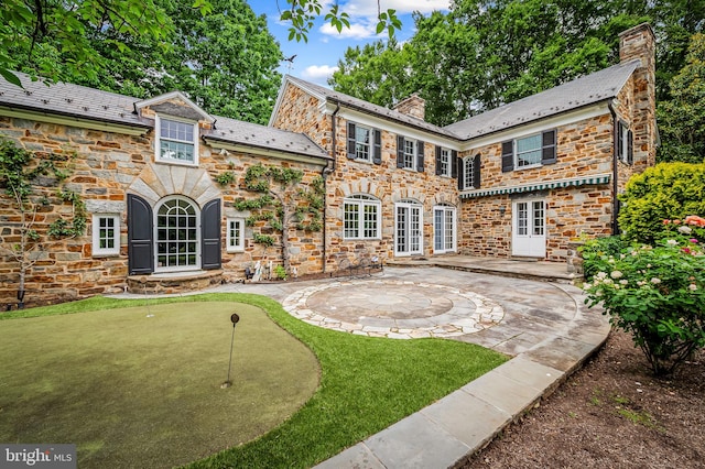 6316 Mossway, Baltimore, MD 21212 - back of property with a chimney, a patio, a putting area, and stone siding