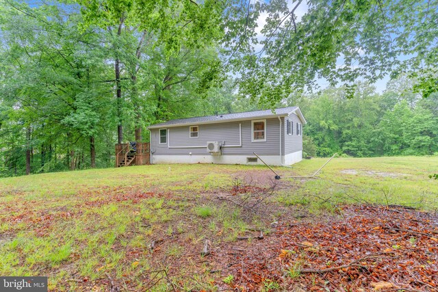 7570 Independence Cir, Charlotte Hall, MD 20622 - rear view of house featuring stairs, a wooden deck, and a lawn
