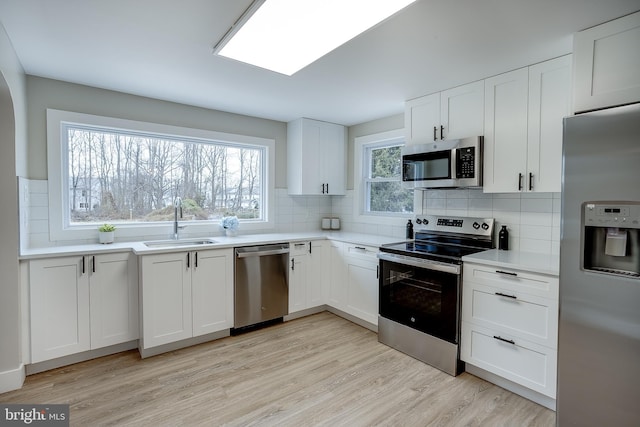 2502 Rancocas Rd, Burlington, NJ 08016 - kitchen with appliances with stainless steel finishes, decorative backsplash, light wood-style floors, and white cabinetry