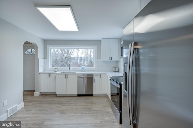 2502 Rancocas Rd, Burlington, NJ 08016 - kitchen featuring stainless steel appliances, backsplash, white cabinetry, and light wood-type flooring