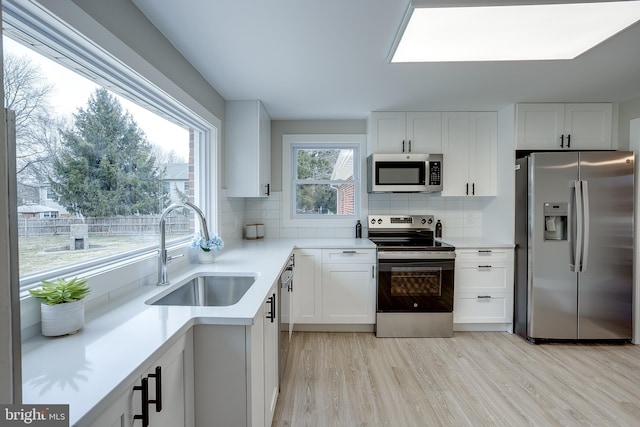 2502 Rancocas Rd, Burlington, NJ 08016 - kitchen with appliances with stainless steel finishes, light wood finished floors, tasteful backsplash, light countertops, and white cabinetry