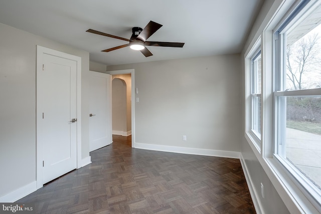 2502 Rancocas Rd, Burlington, NJ 08016 - unfurnished bedroom featuring multiple windows, arched walkways, and a ceiling fan