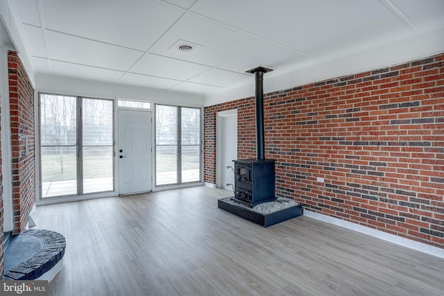2502 Rancocas Rd, Burlington, NJ 08016 - unfurnished living room with brick wall, a wood stove, and wood finished floors