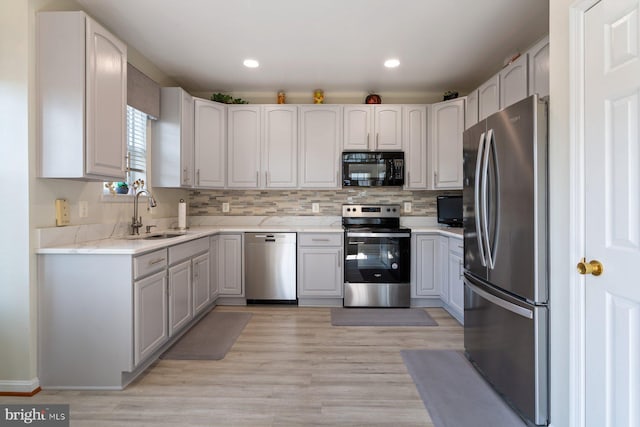 13801 Belle Chasse Blvd Unit 213, Laurel, MD 20707 - kitchen featuring stainless steel appliances, light wood-style flooring, backsplash, recessed lighting, and light stone countertops