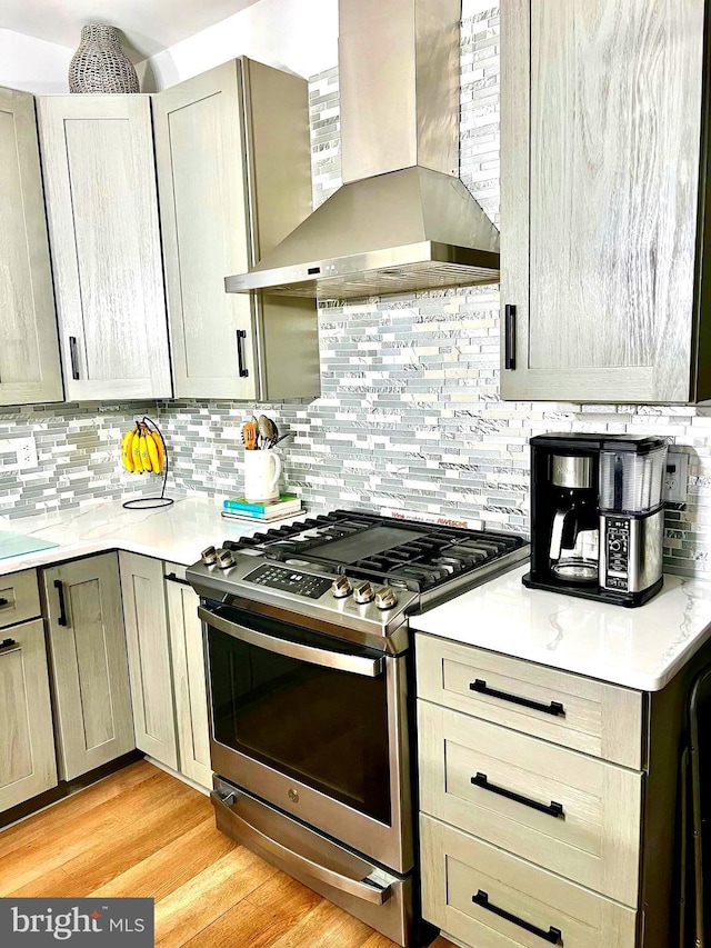 1411 Whispering Woods Ct, Williamstown, NJ 08094 - kitchen featuring stainless steel range with gas stovetop, wall chimney range hood, decorative backsplash, light countertops, and light wood-style floors