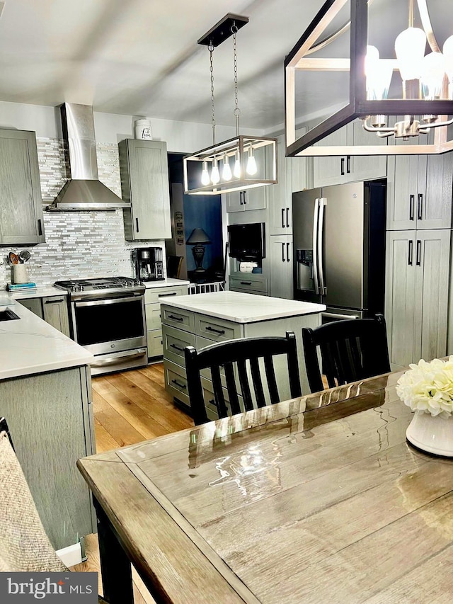 1411 Whispering Woods Ct, Williamstown, NJ 08094 - kitchen with wall chimney exhaust hood, stainless steel appliances, light countertops, tasteful backsplash, and a chandelier