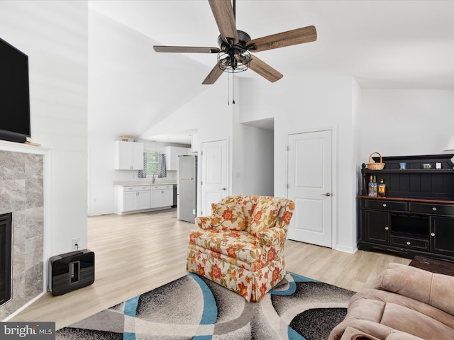 295 Rocky Mount Rd, Linden, VA 22642 - living room with light wood-style flooring, a ceiling fan, high vaulted ceiling, and a tile fireplace