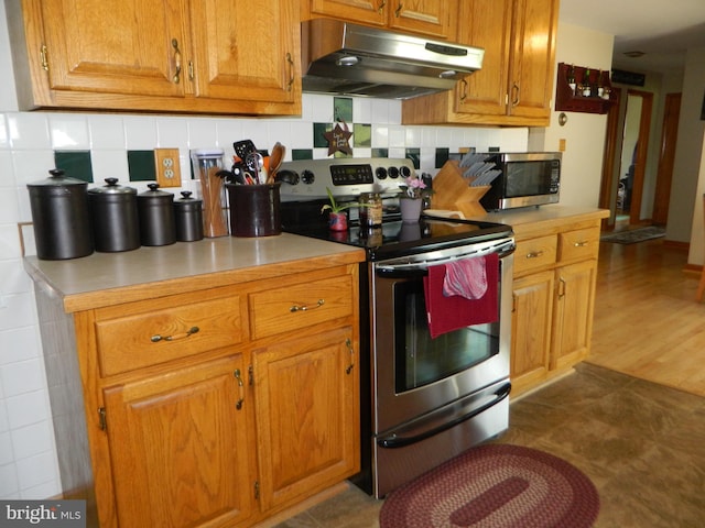 201 Cherry St, Millheim, PA 16854 - kitchen featuring stainless steel appliances, under cabinet range hood, light countertops, and backsplash