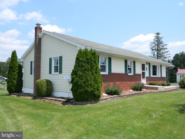 201 Cherry St, Millheim, PA 16854 - view of front of house featuring a chimney, brick siding, and a front yard