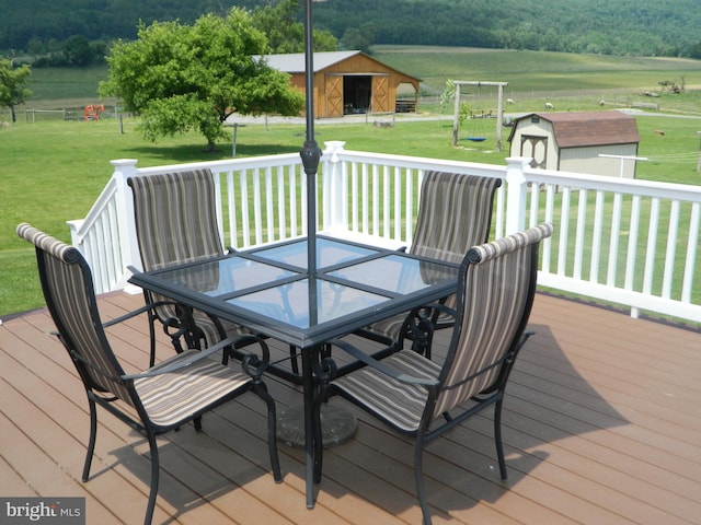 201 Cherry St, Millheim, PA 16854 - wooden deck featuring outdoor dining area, a yard, a shed, and a view of trees