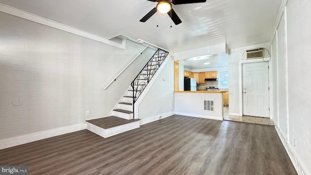 3436 D St, Philadelphia, PA 19134 - unfurnished living room with dark wood finished floors, ceiling fan, stairway, and a wall mounted air conditioner