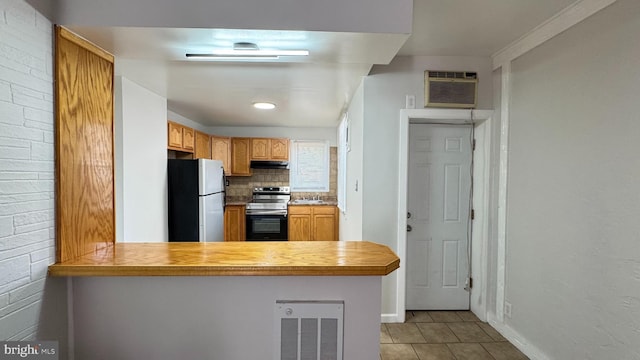 3436 D St, Philadelphia, PA 19134 - kitchen featuring appliances with stainless steel finishes, a wall unit AC, light tile patterned floors, a peninsula, and light countertops