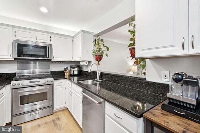 11736 Rockaway Ln Unit 101, Fairfax, VA 22030 - kitchen featuring appliances with stainless steel finishes, dark stone counters, white cabinets, light wood-style floors, and recessed lighting