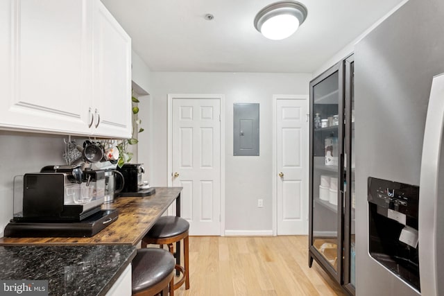 11736 Rockaway Ln Unit 101, Fairfax, VA 22030 - kitchen featuring electric panel, light wood finished floors, white cabinets, and dark stone countertops