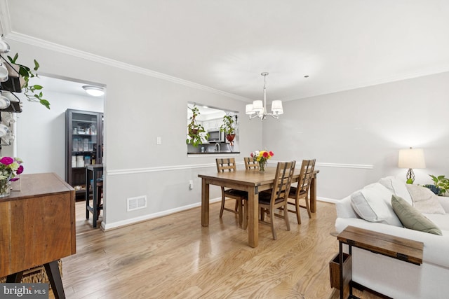 11736 Rockaway Ln Unit 101, Fairfax, VA 22030 - dining room featuring a chandelier, light wood-style flooring, and crown molding