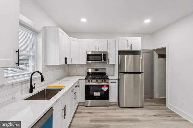 3287 Edgemont St, Philadelphia, PA 19134 - kitchen with stainless steel appliances, light stone countertops, white cabinetry, decorative backsplash, and recessed lighting