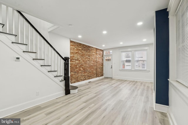 3287 Edgemont St, Philadelphia, PA 19134 - unfurnished living room featuring brick wall, wood finished floors, stairway, and recessed lighting