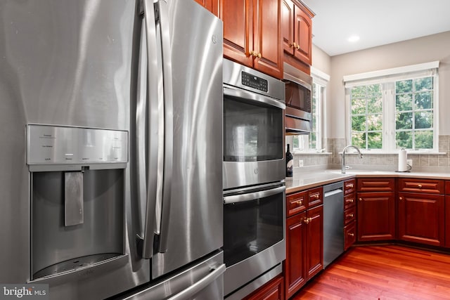 42066 Fiddlehead Pl, Aldie, VA 20105 - kitchen with stainless steel appliances, wood finished floors, light countertops, backsplash, and recessed lighting