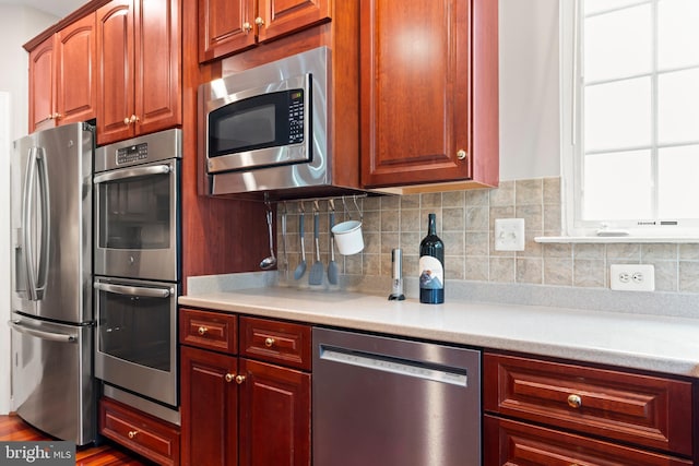 42066 Fiddlehead Pl, Aldie, VA 20105 - kitchen with stainless steel appliances, light countertops, decorative backsplash, and dark wood finished floors