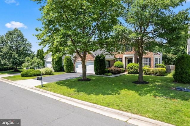 42066 Fiddlehead Pl, Aldie, VA 20105 - obstructed view of property featuring driveway, brick siding, a front lawn, and an attached garage