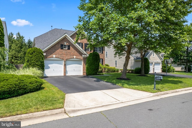 42066 Fiddlehead Pl, Aldie, VA 20105 - view of front of property featuring brick siding, asphalt driveway, a front yard, a garage, and a shingled roof