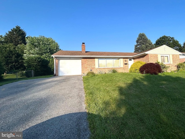 305 Reservoir Rd, Mechanicsburg, PA 17055 - single story home with a chimney, brick siding, an attached garage, asphalt driveway, and a front yard