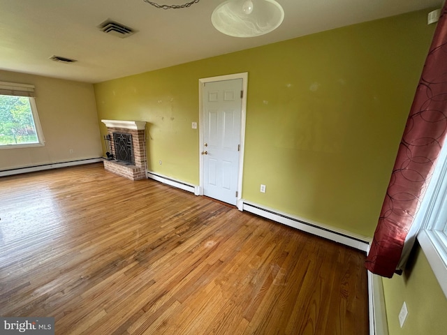 305 Reservoir Rd, Mechanicsburg, PA 17055 - unfurnished living room with a baseboard radiator, wood finished floors, and a brick fireplace