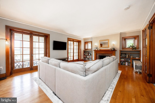 727 W Baltimore Pike, Kennett Square, PA 19348 - living room featuring french doors, light wood-style flooring, a fireplace, and ornamental molding