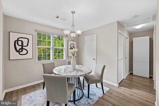 2050 N Calvert St Unit 410, Arlington, VA 22201 - dining room with light wood-style flooring, a chandelier, and attic access