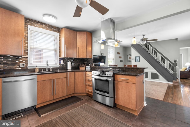 7615 Belmont Ave, Baltimore, MD 21224 - kitchen featuring appliances with stainless steel finishes, a ceiling fan, island range hood, a peninsula, and brown cabinets