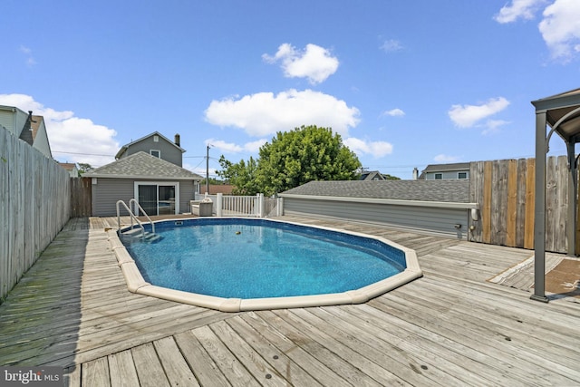 7615 Belmont Ave, Baltimore, MD 21224 - view of swimming pool featuring a deck, a fenced backyard, and an outbuilding
