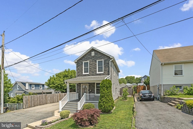 7615 Belmont Ave, Baltimore, MD 21224 - traditional home featuring a porch, stone siding, and asphalt driveway