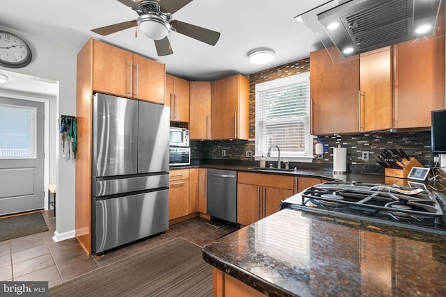 7615 Belmont Ave, Baltimore, MD 21224 - kitchen featuring stainless steel appliances, exhaust hood, dark tile patterned flooring, and tasteful backsplash