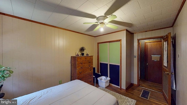 10495 Knobley Rd, Keyser, WV 26726 - bedroom with wood finished floors, ornamental molding, a ceiling fan, a closet, and wood walls
