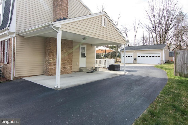 12008 Montague Dr, Laurel, MD 20708 - view of home's exterior featuring an outdoor structure, brick siding, a garage, and a chimney