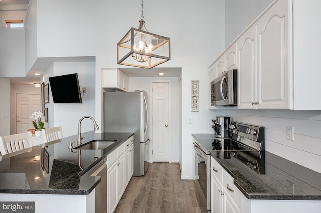245 Blue Bill Ln Unit 245-D, Havre De Grace, MD 21078 - kitchen featuring appliances with stainless steel finishes, a high ceiling, a peninsula, white cabinetry, and light wood-type flooring