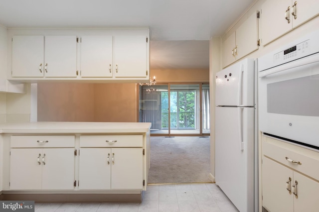 3360 Gleneagles Dr Unit 71-2B, Silver Spring, MD 20906 - kitchen featuring white appliances, light countertops, light colored carpet, white cabinets, and a peninsula