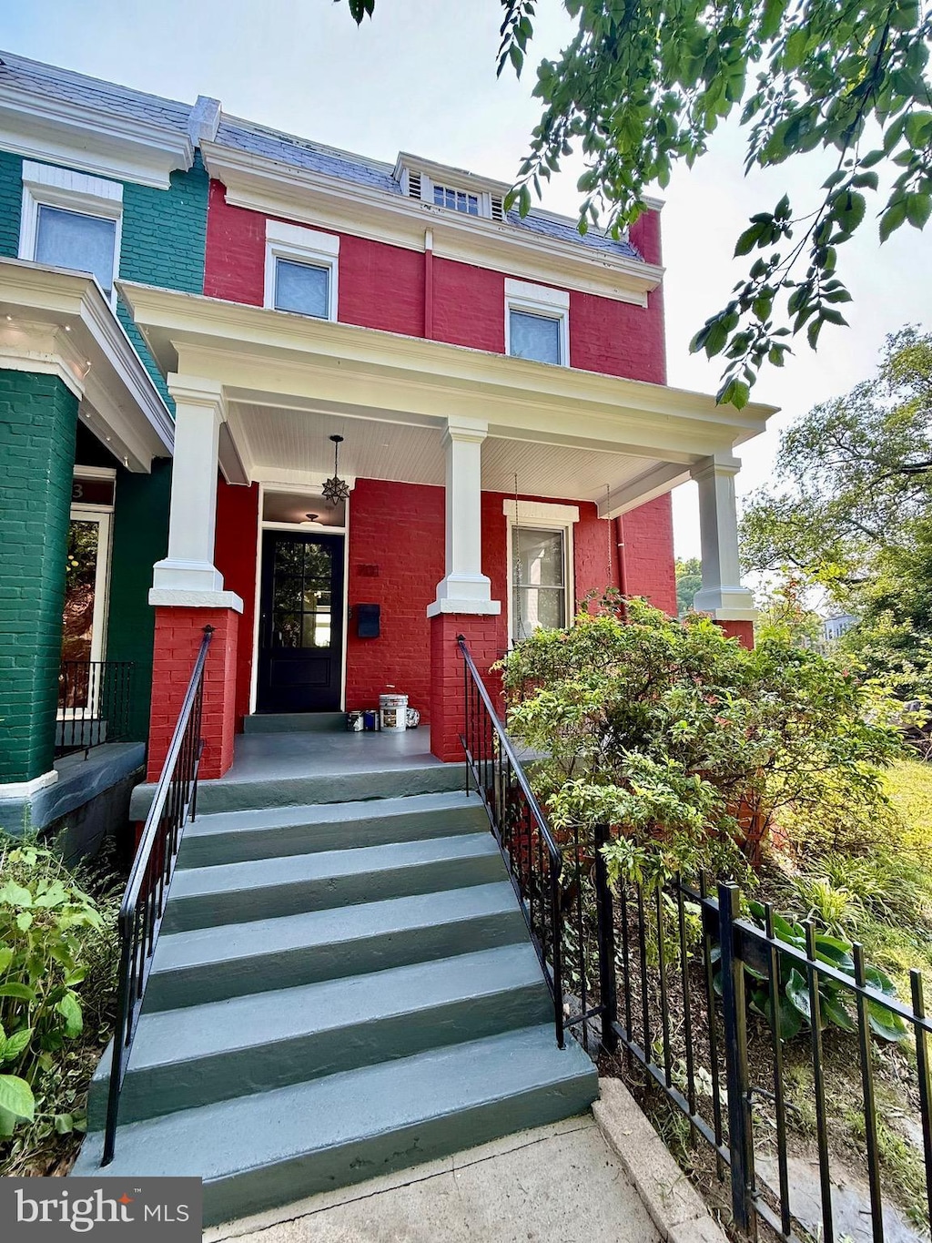 701 Kentucky Ave SE, Washington, DC 20003 - view of front facade featuring covered porch, brick siding, and mansard roof
